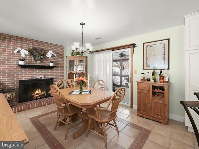 dining room with an inviting chandelier, light tile patterned floors, and a fireplace