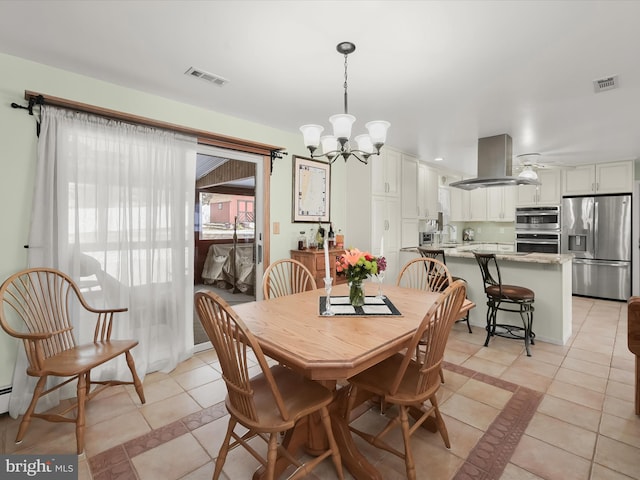 dining area featuring sink, a chandelier, and light tile patterned floors