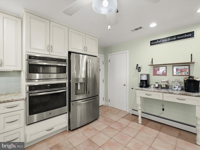 kitchen with a baseboard heating unit, light tile patterned floors, decorative backsplash, white cabinets, and stainless steel appliances