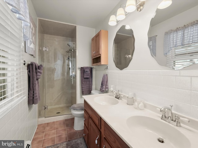 bathroom featuring a shower with shower door, toilet, tile walls, tile patterned flooring, and vanity