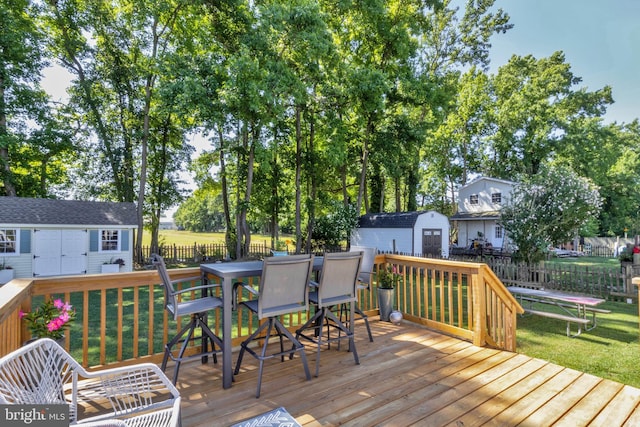 wooden deck featuring a yard and a storage unit