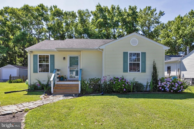 view of front of home featuring an outbuilding and a front lawn