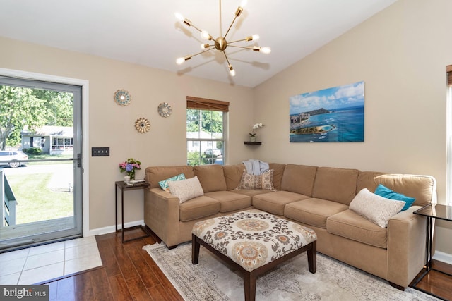 living room with wood-type flooring, vaulted ceiling, and a notable chandelier