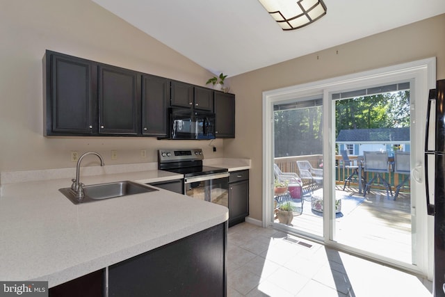 kitchen with light tile patterned floors, electric range, vaulted ceiling, and sink