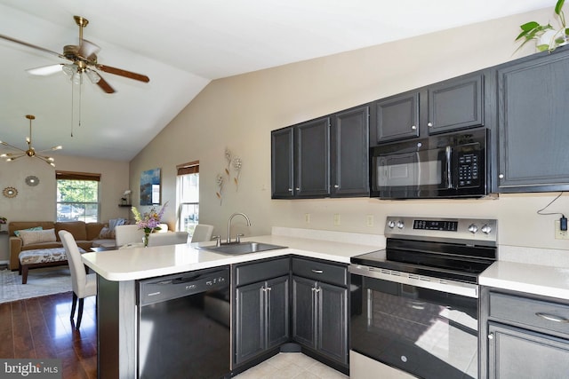 kitchen with black appliances, sink, vaulted ceiling, light hardwood / wood-style floors, and kitchen peninsula