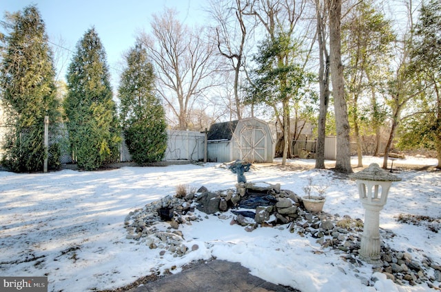 snowy yard featuring a storage unit