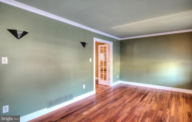 empty room with hardwood / wood-style floors and ornamental molding