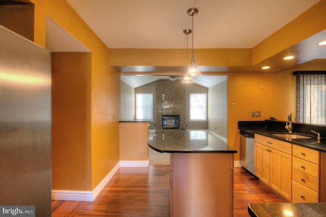 kitchen featuring stainless steel dishwasher, dark hardwood / wood-style floors, light brown cabinetry, decorative light fixtures, and a kitchen island