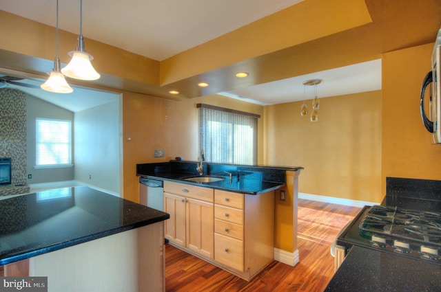 kitchen with decorative light fixtures, sink, and an island with sink