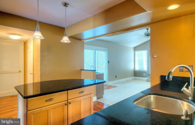 kitchen with lofted ceiling, sink, ceiling fan, light brown cabinetry, and decorative light fixtures