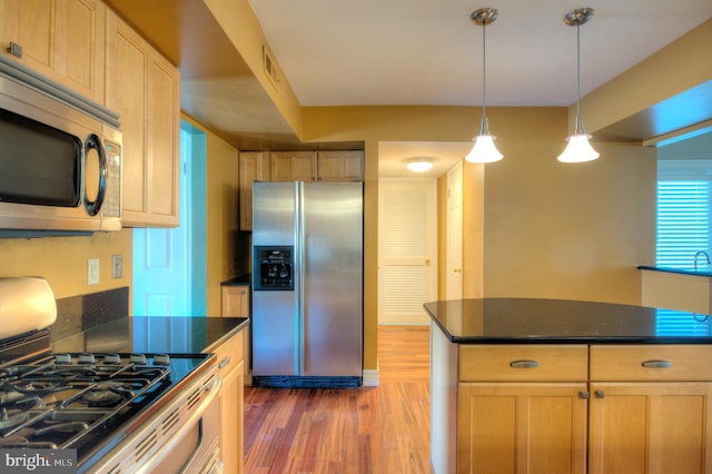 kitchen with hardwood / wood-style flooring, a center island, light brown cabinets, and stainless steel appliances