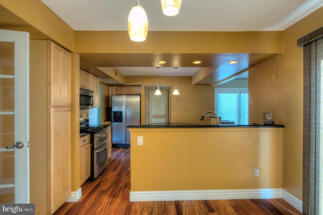 kitchen featuring sink, stainless steel appliances, hanging light fixtures, and dark hardwood / wood-style floors