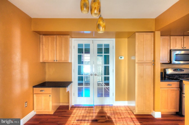 kitchen with appliances with stainless steel finishes, light brown cabinetry, french doors, and pendant lighting