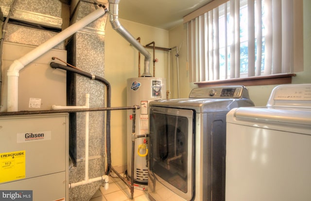 laundry area featuring light tile patterned flooring, gas water heater, and washing machine and clothes dryer