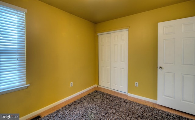 unfurnished bedroom featuring hardwood / wood-style floors and a closet