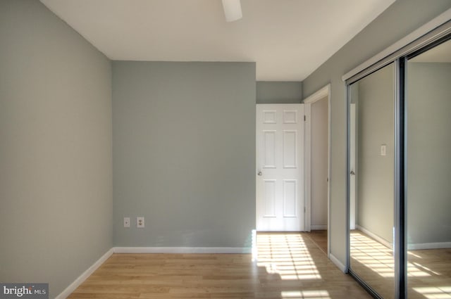 unfurnished bedroom with ceiling fan, light hardwood / wood-style floors, and a closet