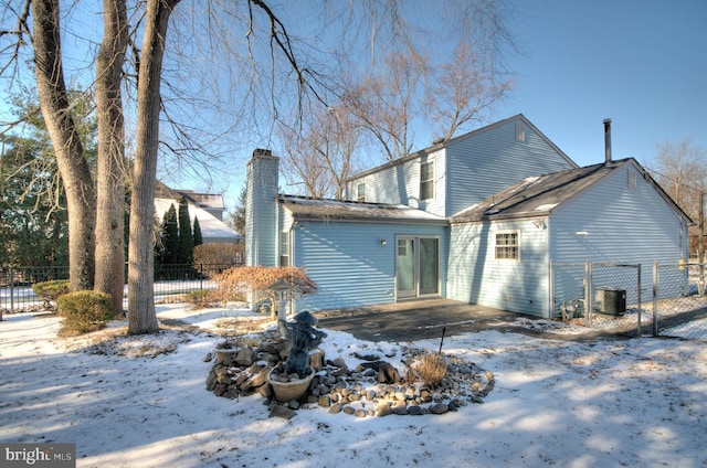 snow covered property with a patio area and cooling unit