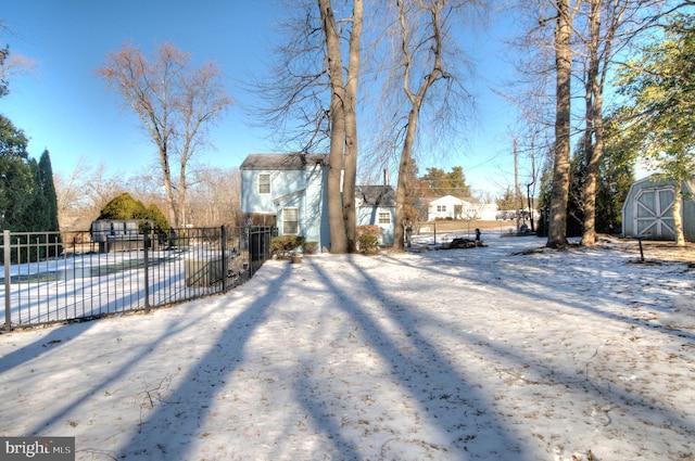 snowy yard with a storage shed