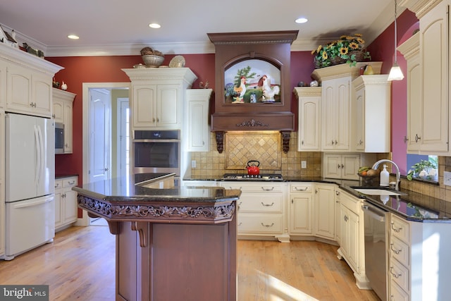 kitchen featuring appliances with stainless steel finishes, backsplash, sink, pendant lighting, and a kitchen island