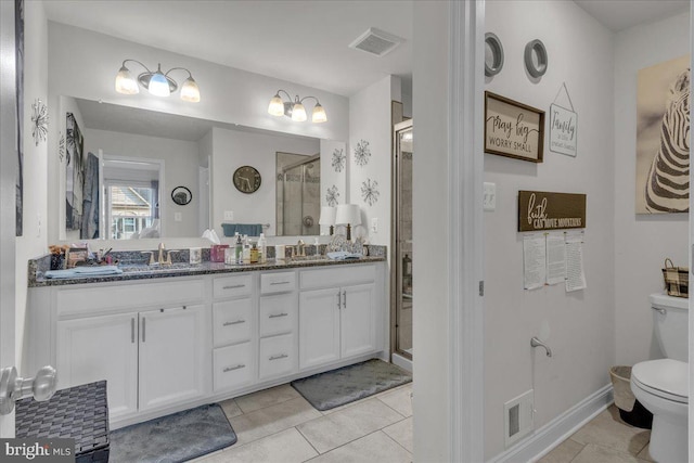 bathroom with tile patterned floors, vanity, toilet, and walk in shower