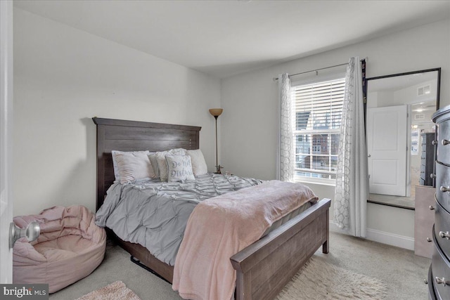 carpeted bedroom featuring multiple windows