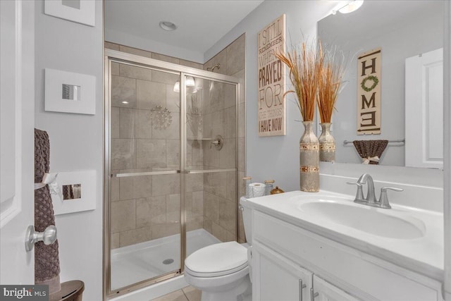 bathroom with vanity, toilet, and a shower with shower door