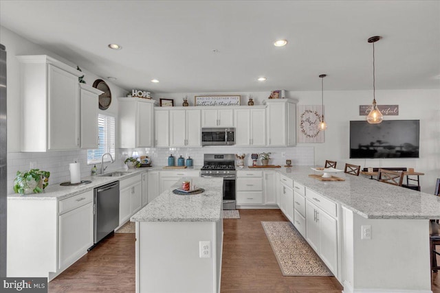 kitchen with pendant lighting, a center island, stainless steel appliances, and a breakfast bar area