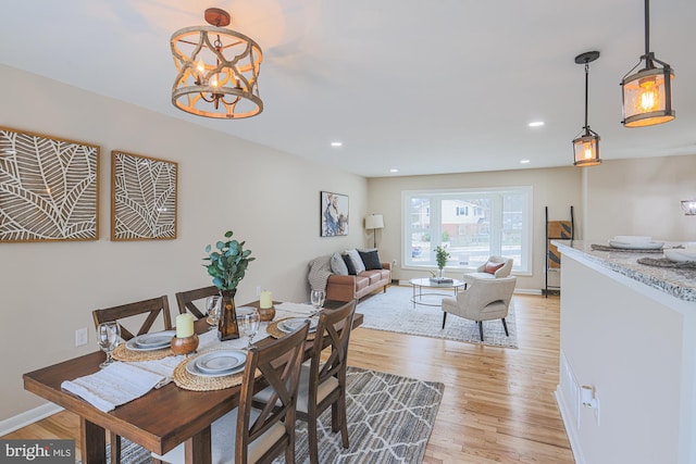 dining space featuring a chandelier and light wood-type flooring