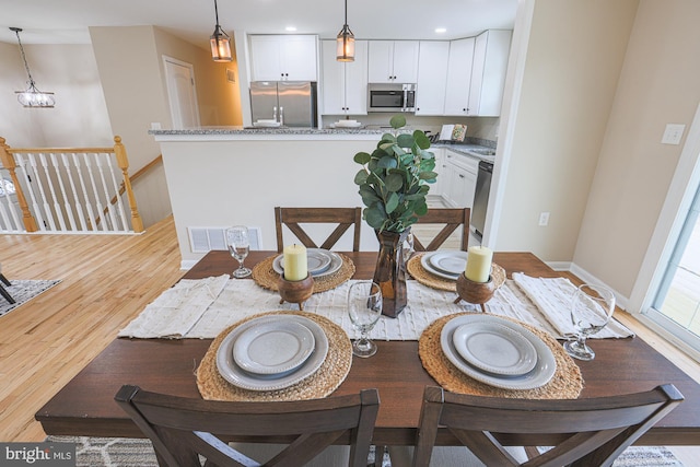 dining space featuring a chandelier and light hardwood / wood-style flooring