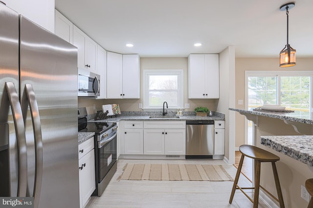 kitchen featuring light stone counters, white cabinetry, and appliances with stainless steel finishes