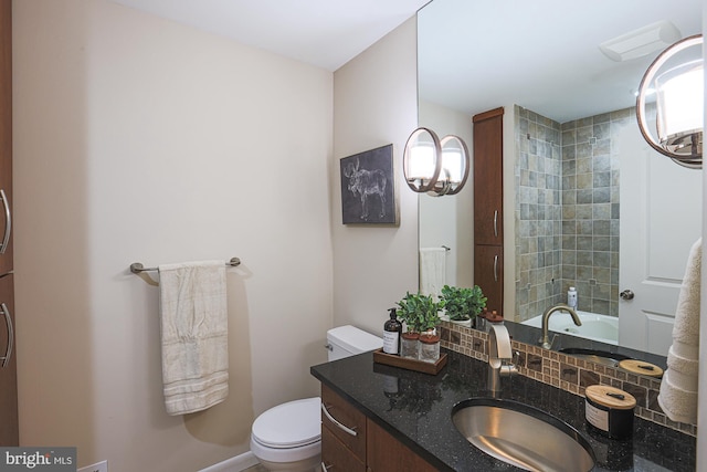 bathroom with tasteful backsplash, a tub to relax in, vanity, and toilet