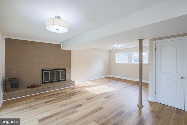 basement with a fireplace and light hardwood / wood-style flooring