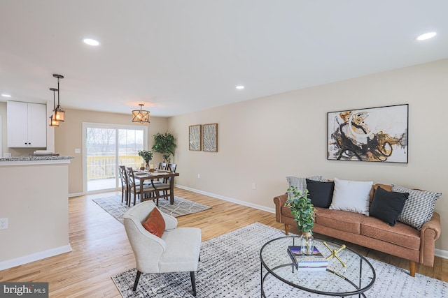 living room with light hardwood / wood-style flooring and an inviting chandelier