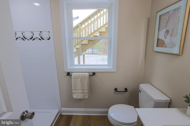 bathroom featuring a shower, hardwood / wood-style floors, vanity, and toilet