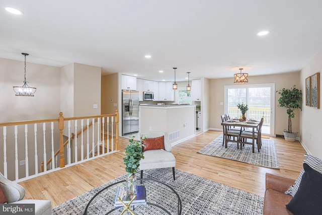 living room with light hardwood / wood-style floors and a chandelier