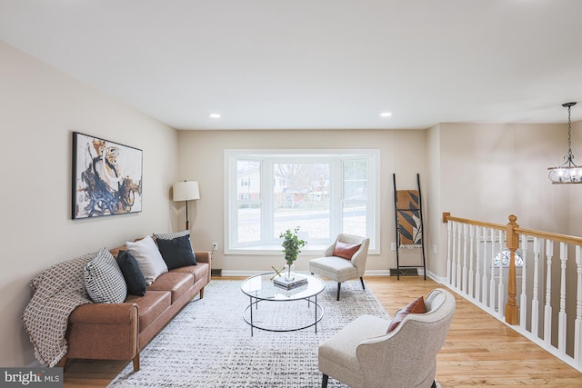 living room with light hardwood / wood-style floors and an inviting chandelier