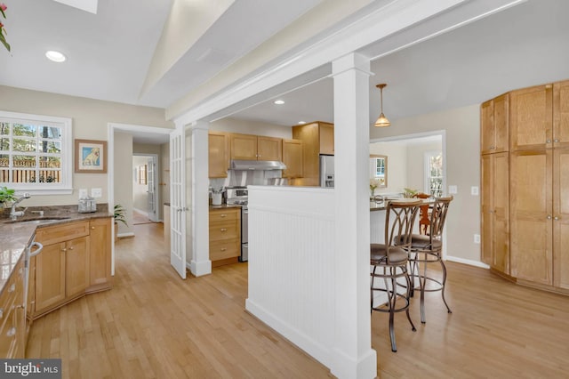 kitchen with lofted ceiling, sink, ornate columns, light hardwood / wood-style flooring, and hanging light fixtures