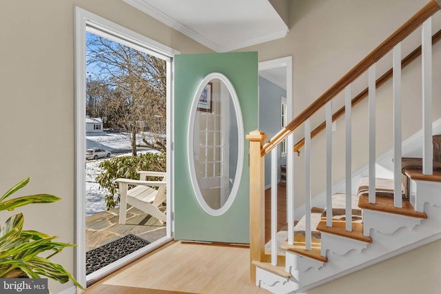 foyer with crown molding and light hardwood / wood-style flooring