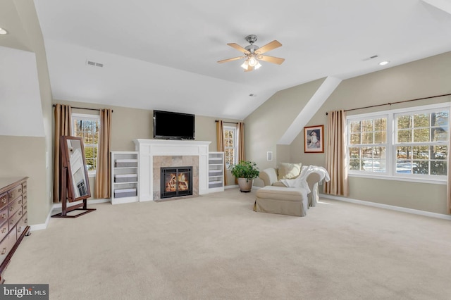 carpeted living room with vaulted ceiling, plenty of natural light, ceiling fan, and a fireplace