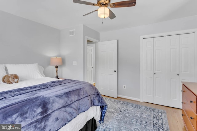 bedroom with light hardwood / wood-style floors, a closet, and ceiling fan