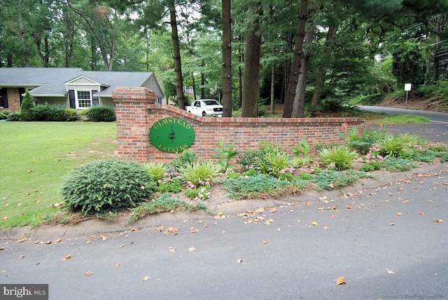 community / neighborhood sign featuring a yard