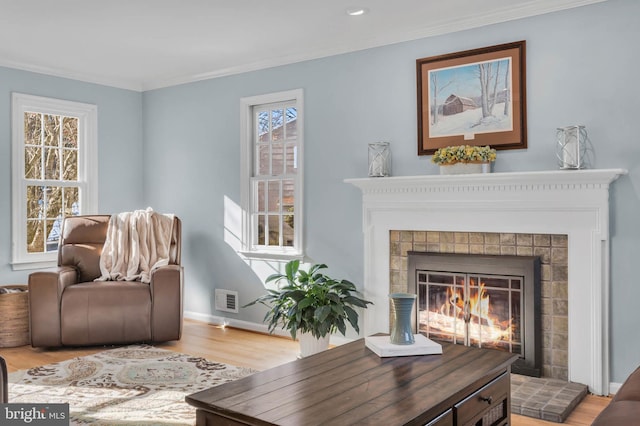 sitting room with wood-type flooring and ornamental molding