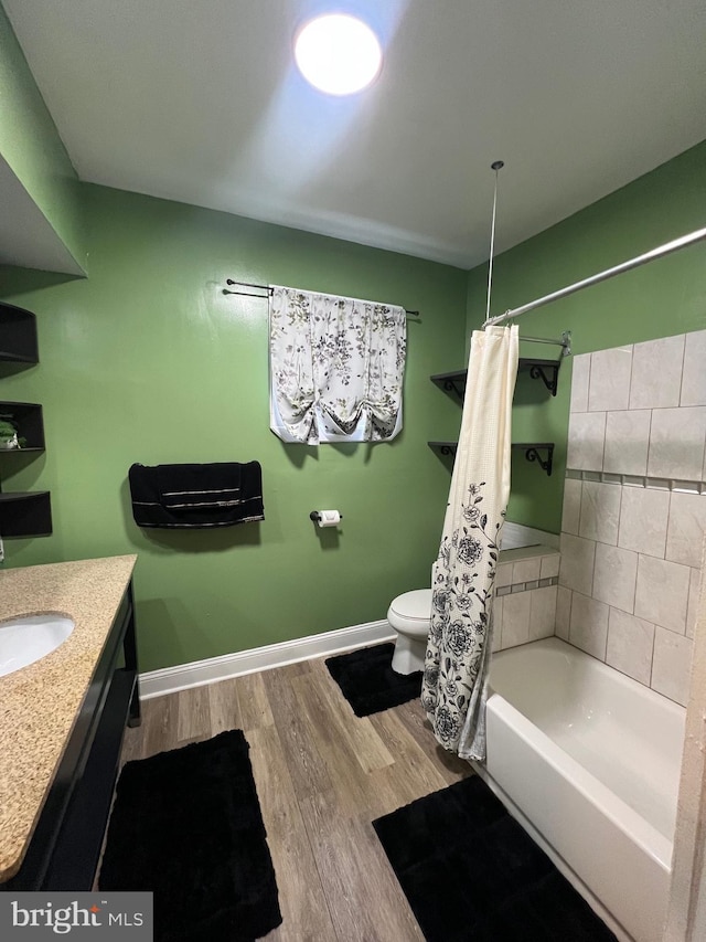 full bathroom with hardwood / wood-style flooring, vanity, toilet, and shower / tub combo with curtain