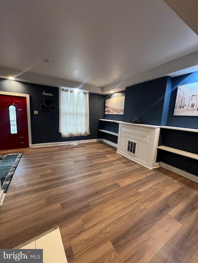 unfurnished living room with wood-type flooring