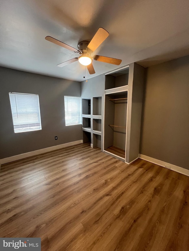 unfurnished bedroom with hardwood / wood-style flooring, ceiling fan, and a closet