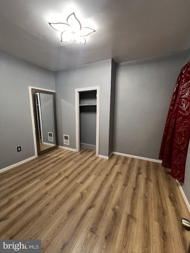 unfurnished bedroom with hardwood / wood-style floors