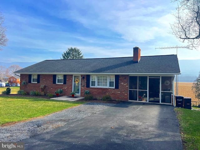 single story home featuring a sunroom and a front lawn