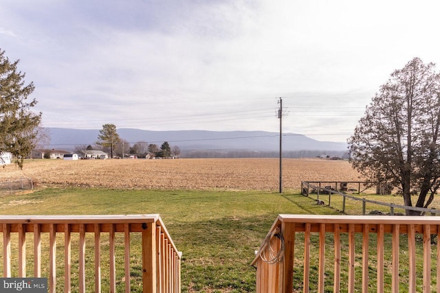 view of yard with a rural view and a deck with mountain view