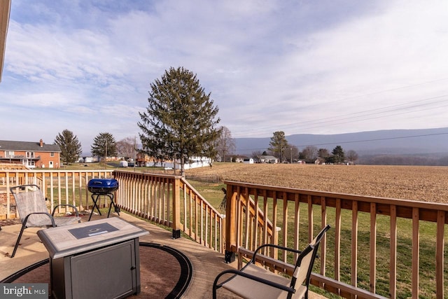 wooden terrace featuring a mountain view and a yard