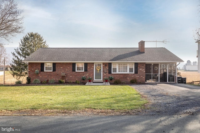 ranch-style house with a sunroom and a front yard